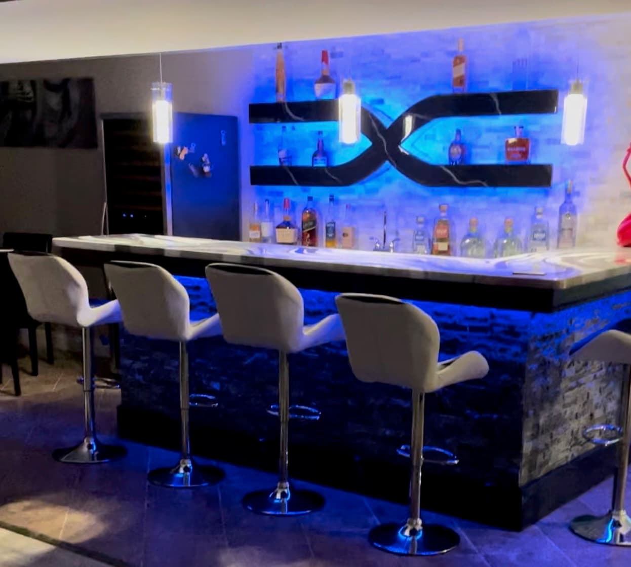 Custom basement bar with LED lighting and stone veneer in Maryland by Atlantic Construction