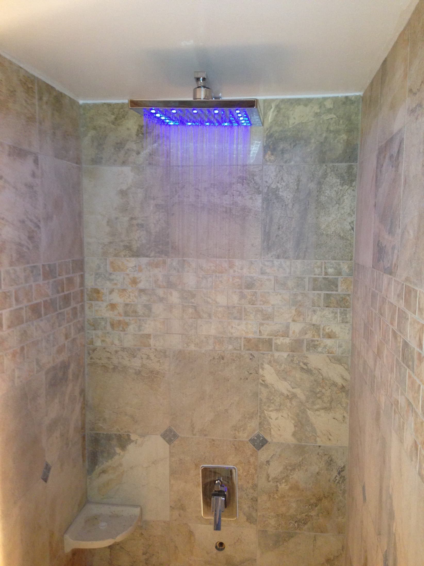 Custom travertine tile shower with LED rainfall showerhead in DC by Atlantic Construction