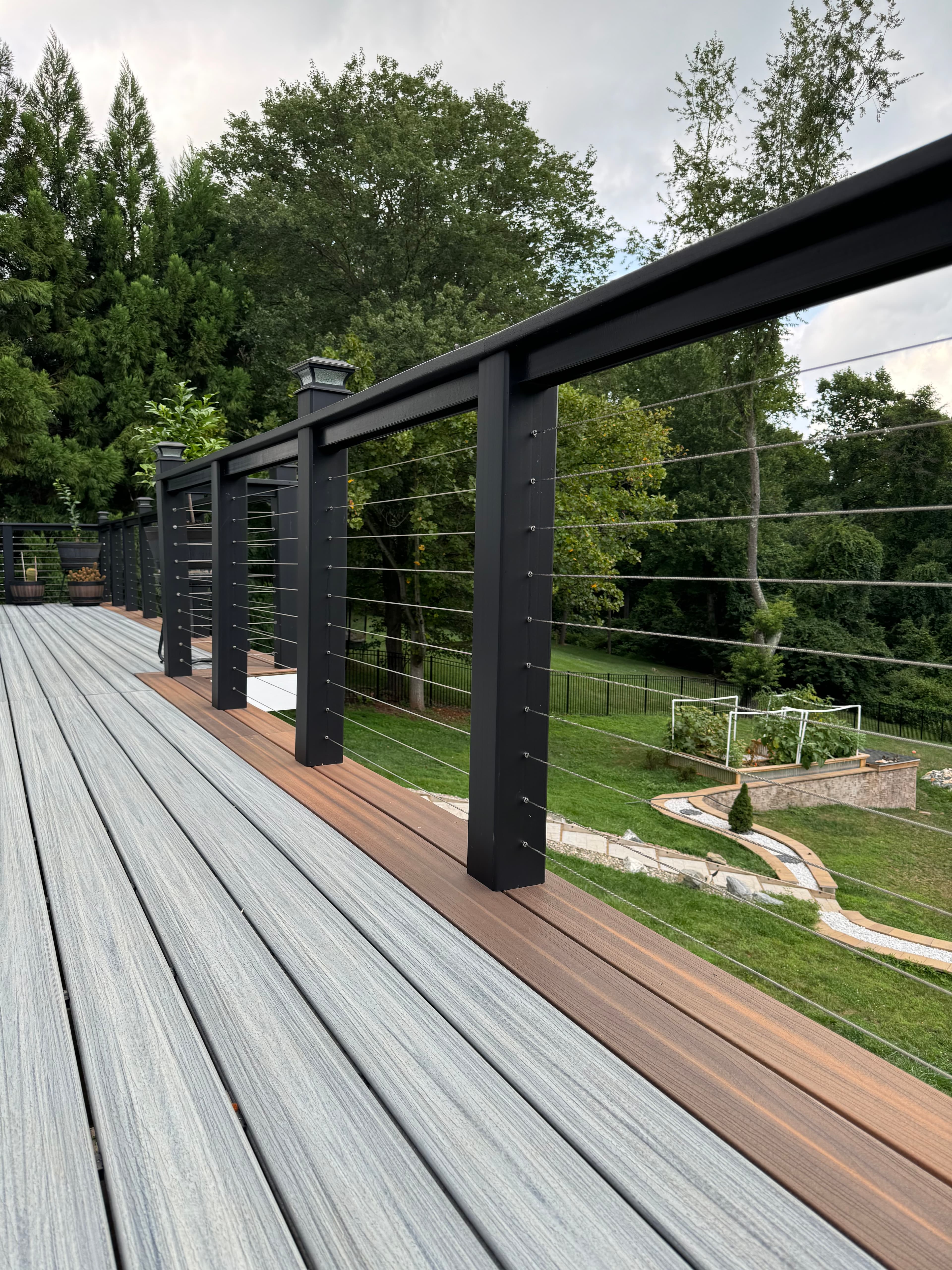 Stunning modern deck with black aluminum frame and cable rail system in Virginia by Atlantic Construction
