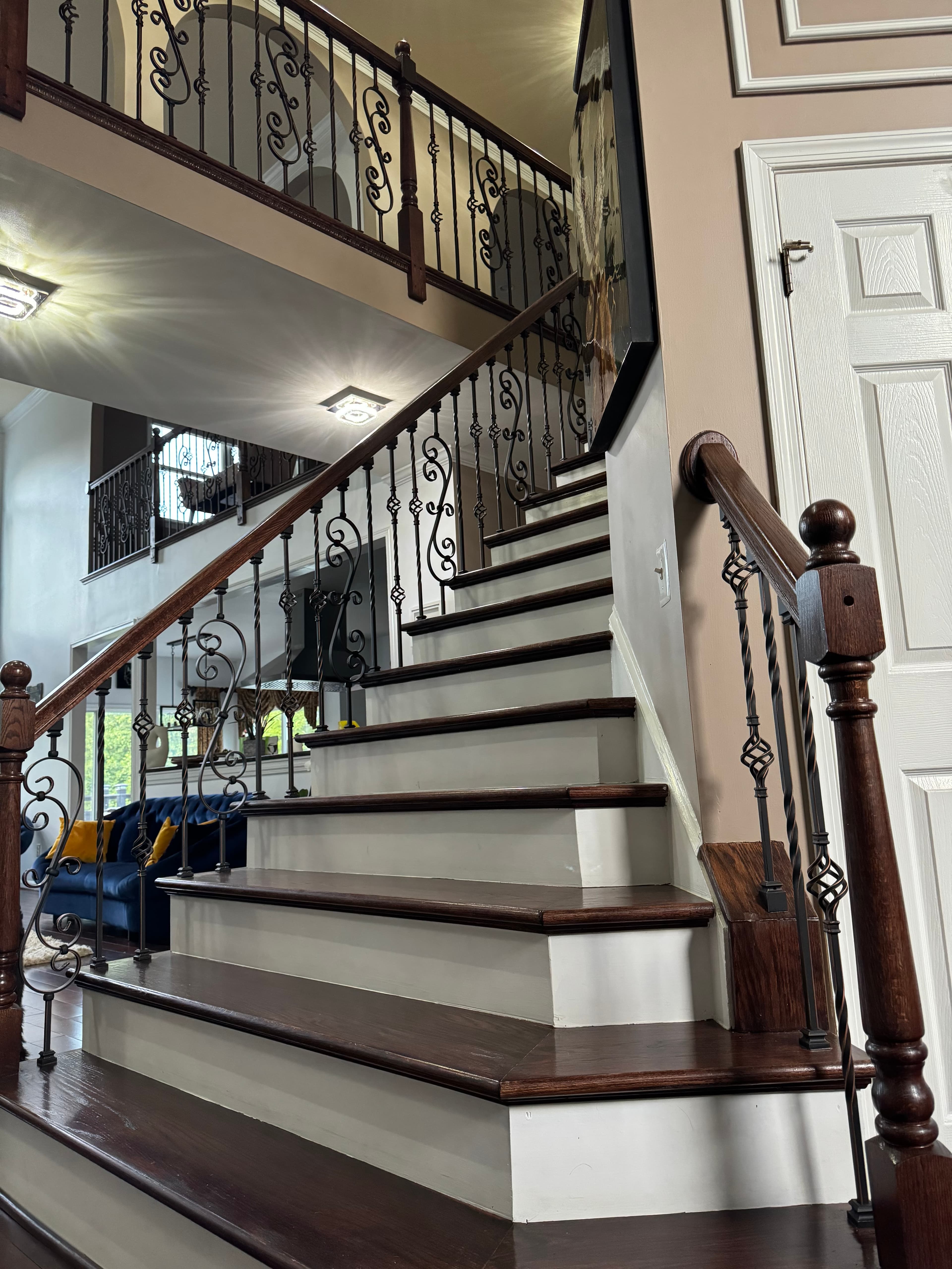 Luxury residential staircase with custom wrought iron railings and hardwood treads in Maryland by Atlantic Construction