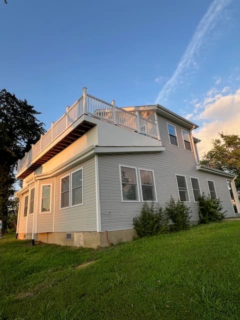 Beautiful residential home with completed second story deck addition with white railings in DC by Atlantic Construction