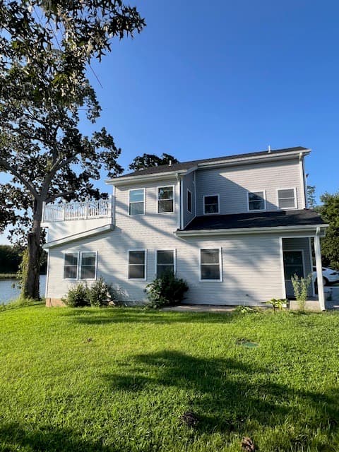 Beautiful completed residential waterfront home with modern gray and white siding and upper deck in Virginia by Atlantic Construction