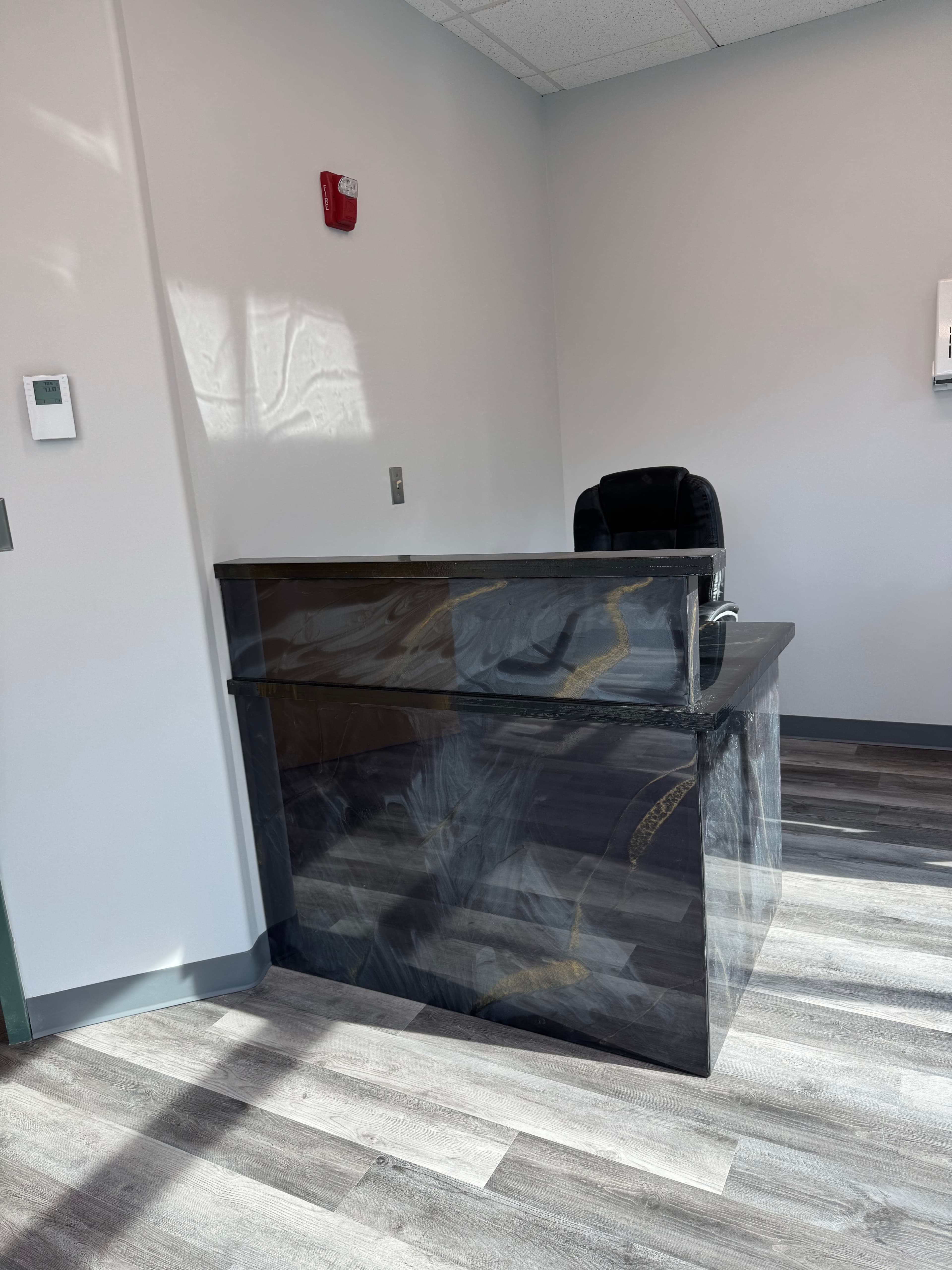 Commercial reception desk with custom stone panel and luxury vinyl flooring in DC by Atlantic Construction
