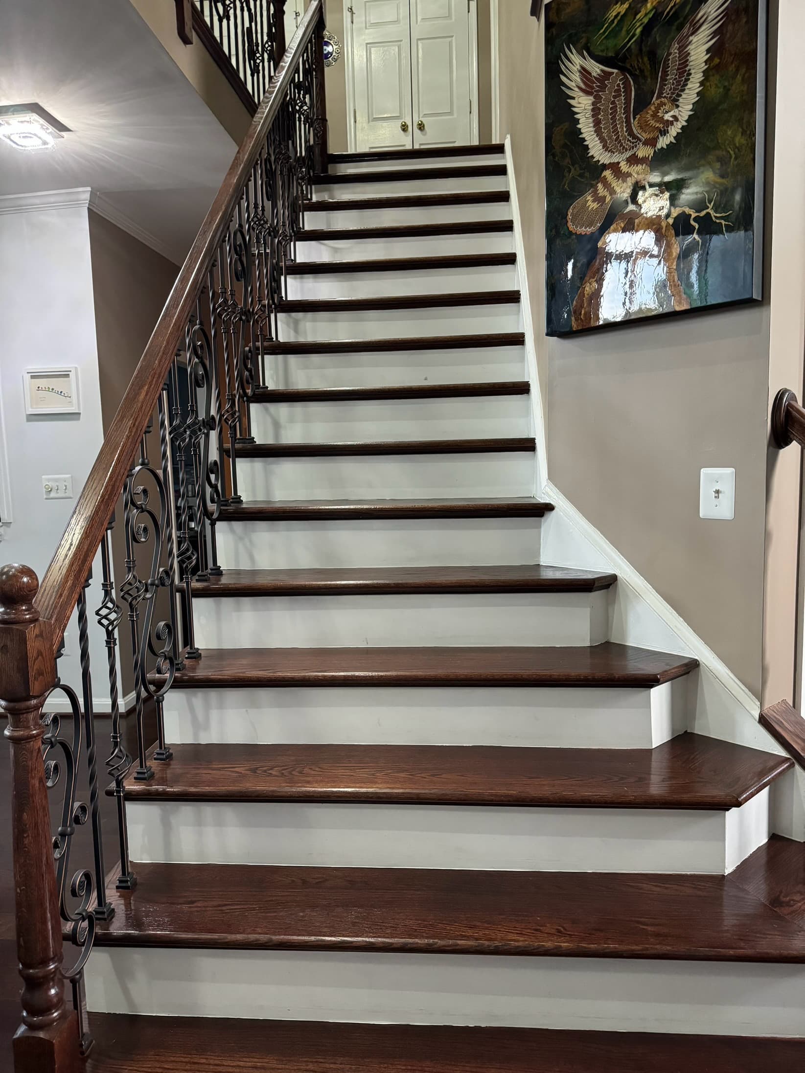 Luxury residential staircase with custom wrought iron railings and hardwood treads in Maryland by Atlantic Construction